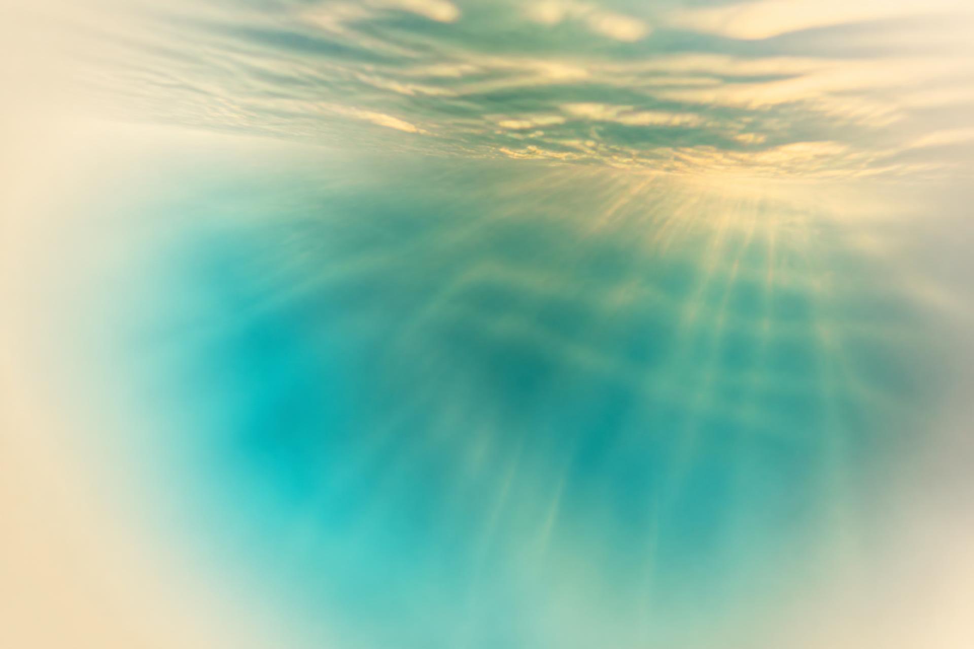 Soft-focus turquoise water with gold light rays